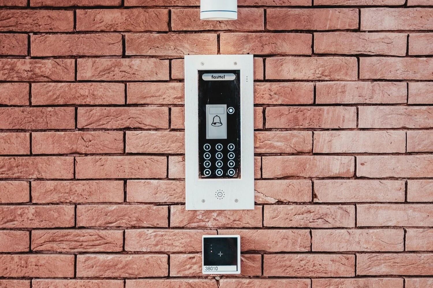 Digital door lock system installed against a brick wall